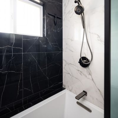 black and white shower tile system with black shower head
